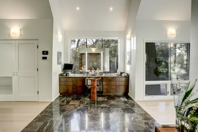 a room with lots of wooden furniture and windows