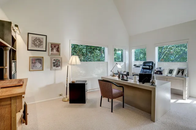 a view of a workspace with furniture and a window