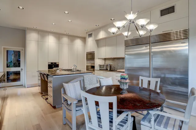 a kitchen with a dining table chairs sink and stove