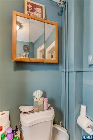 a bathroom with a toilet a sink and mirror