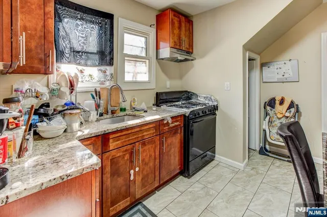 a kitchen with stainless steel appliances granite countertop a stove top oven a sink and dishwasher