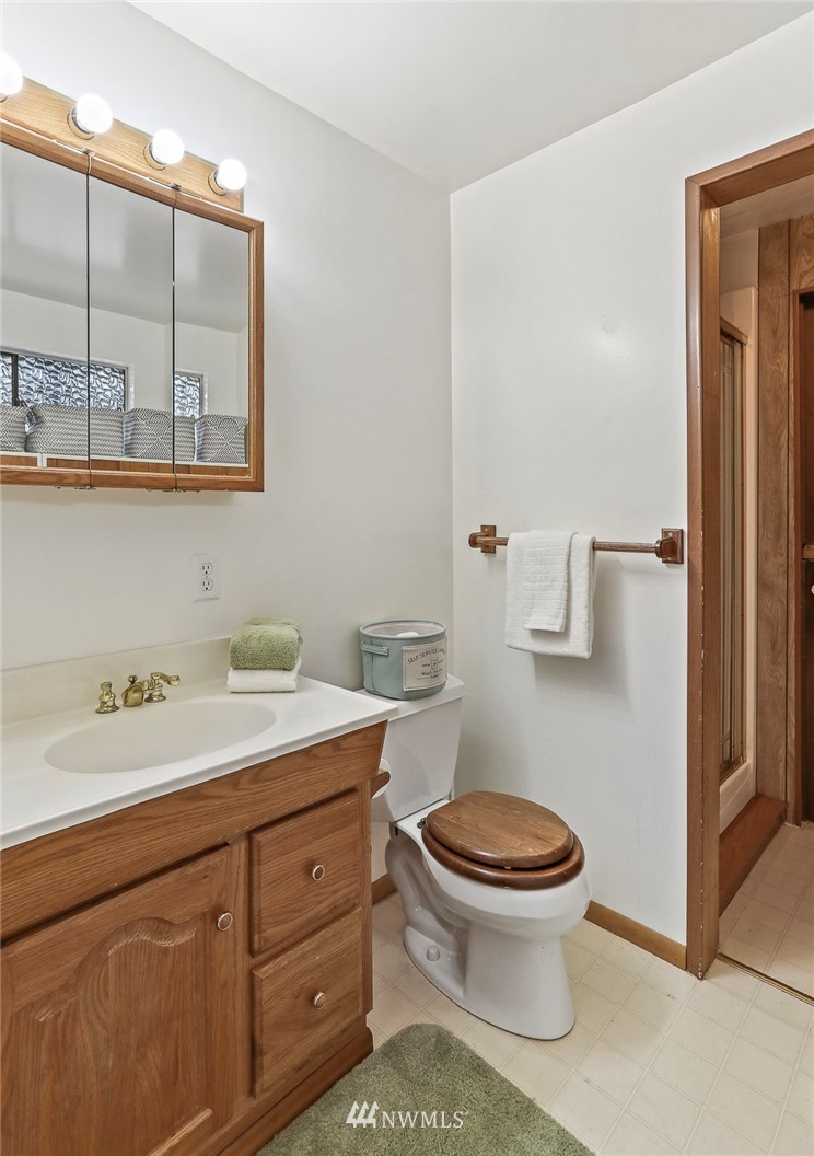 14405 Southeast 142nd Place Renton, WA 98059 - Photo 22 of 28 a bathroom with a granite countertop toilet sink and mirror