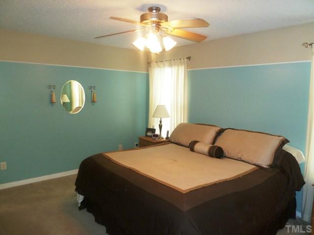 4112 Hopper Street Raleigh, NC 27616 - Photo 9 of 25 a bedroom with a bed and a chandelier