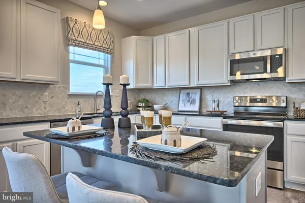 a kitchen with kitchen island granite countertop a sink cabinets and stainless steel appliances