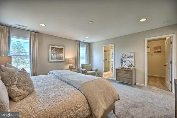 a spacious bedroom with a large bed and a dresser
