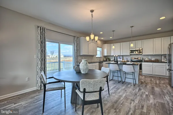 a open dining room with stainless steel appliances kitchen island granite countertop a stove a kitchen island a dining table and chairs