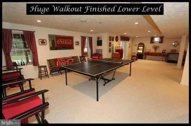 a living room with furniture a flat screen tv and kitchen view