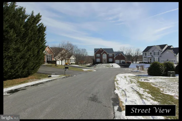 a view of a house with yard and trees in the background