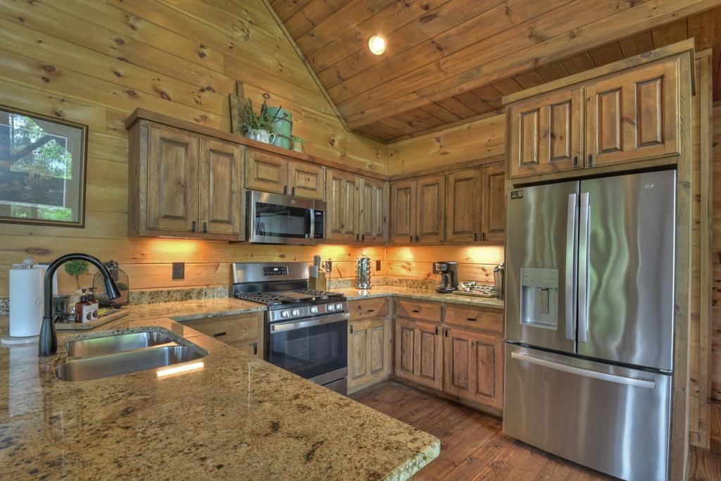 401 Foster Cove Road Epworth, GA 30541 - Photo 27 of 51 a kitchen with granite countertop a sink stainless steel appliances and cabinets