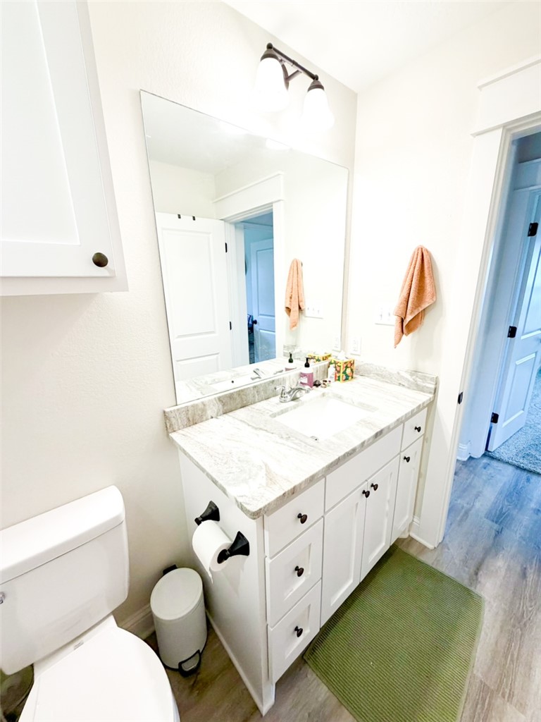 148 Turnrow Cove Somerville, TX 77879 - Photo 12 of 32 a bathroom with a granite countertop sink mirror vanity and toilet
