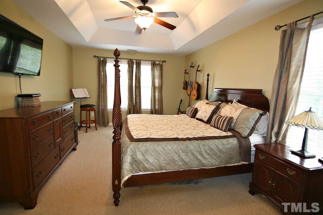 4109 Batiste Road Raleigh, NC 27613 - Photo 14 of 25 a bedroom with a bed and a chandelier