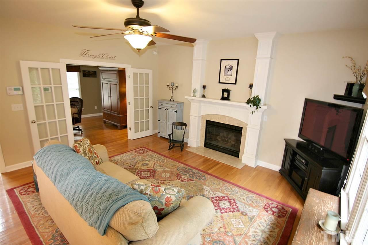 4109 Batiste Road Raleigh, NC 27613 - Photo 9 of 25 a living room with furniture fireplace and a flat screen tv