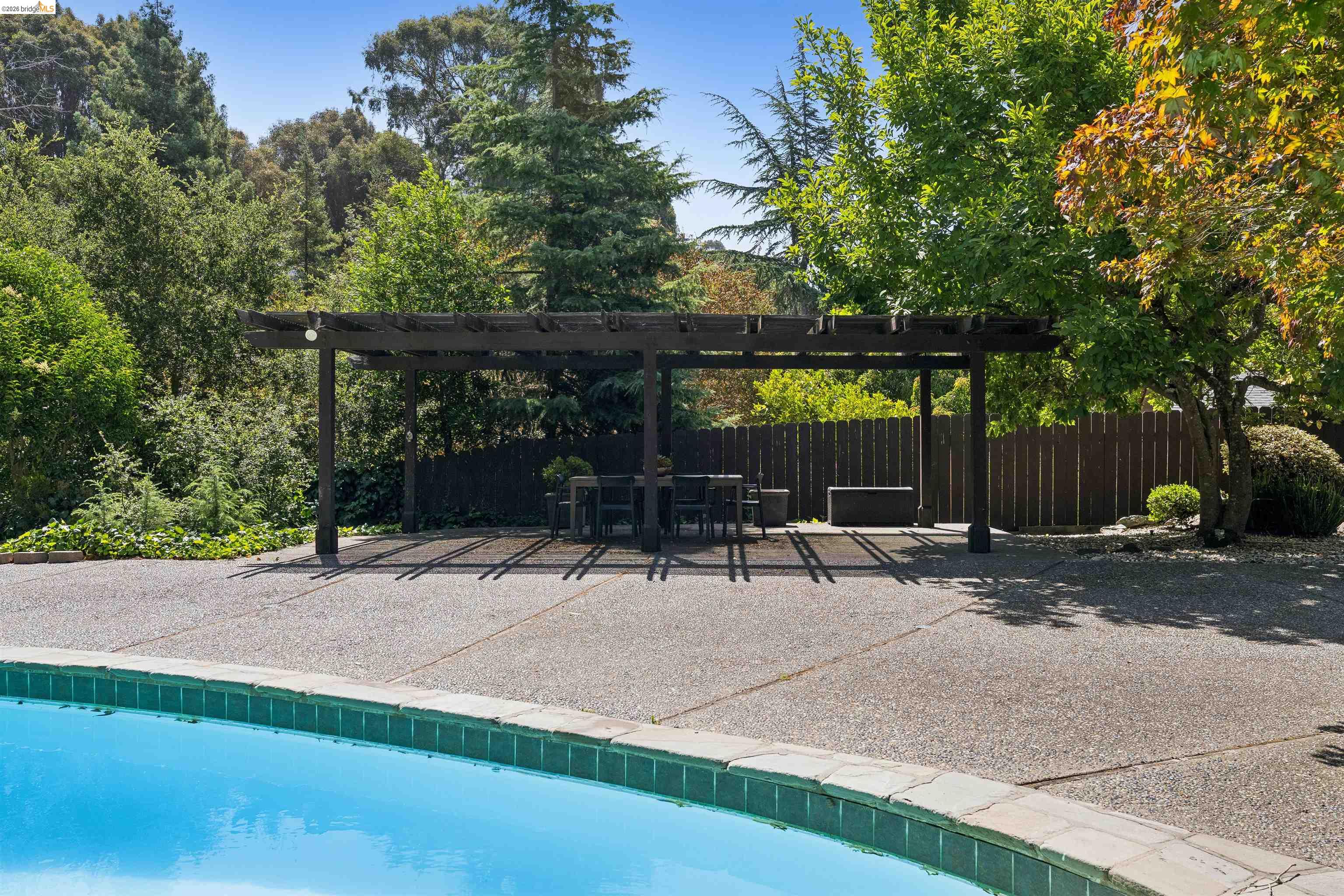 7 Jo Lin Court El Sobrante, CA 94803 - Photo 89 of 99 Expansive backyard featuring a large swimming pool with tile coping, an exposed aggregate concrete patio, and a substantial wooden pergola