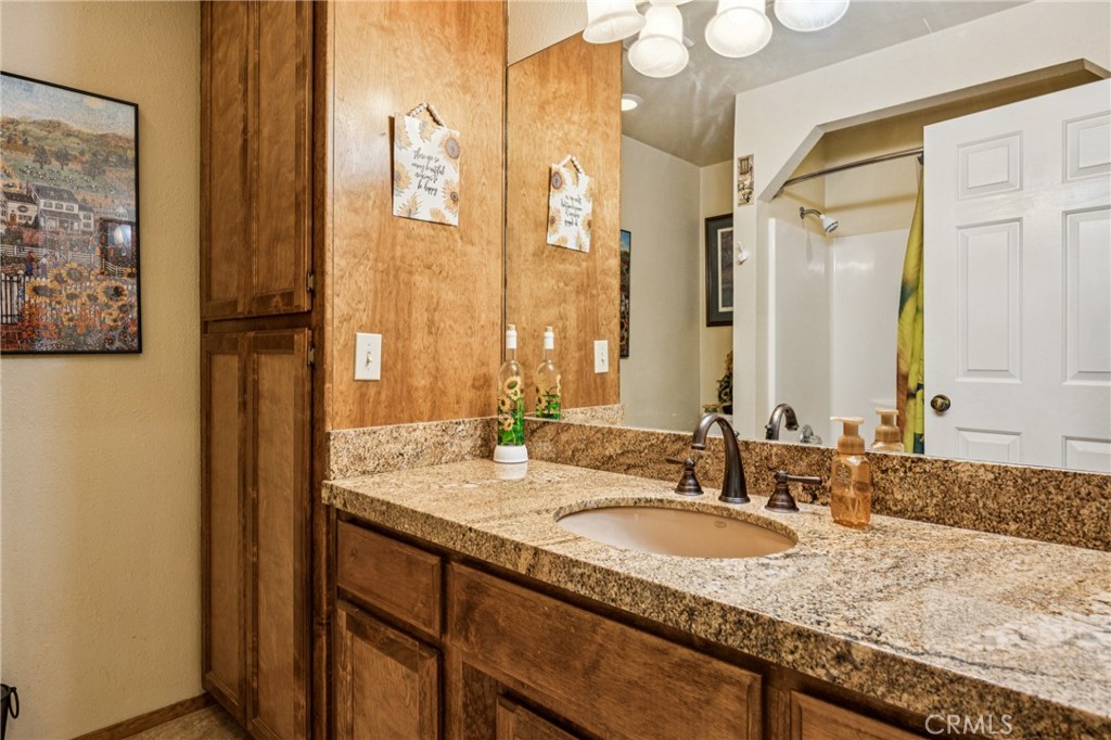 7050 Shale Rock Road Paso Robles, CA 93446 - Photo 25 of 45 a bathroom with a granite countertop sink and a mirror