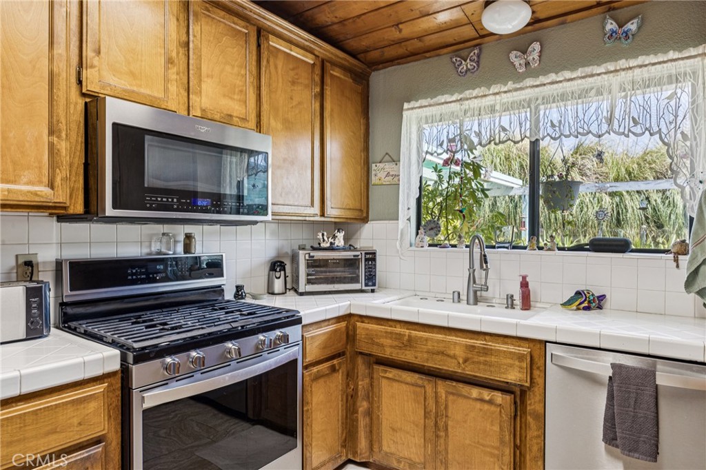 7050 Shale Rock Road Paso Robles, CA 93446 - Photo 9 of 45 a kitchen with stainless steel appliances a stove a sink a microwave and cabinets