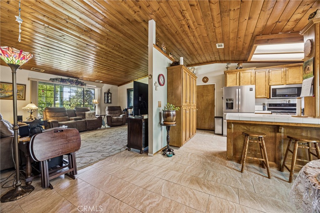 7050 Shale Rock Road Paso Robles, CA 93446 - Photo 10 of 45 a kitchen with stainless steel appliances kitchen island granite countertop dining table chairs cabinets and a sink