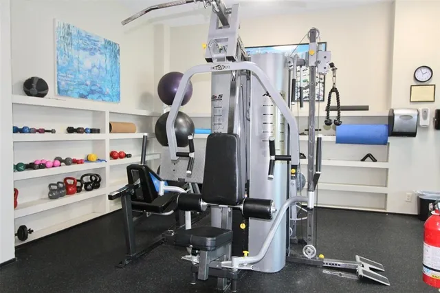 a view of an empty room with wooden floor and windows