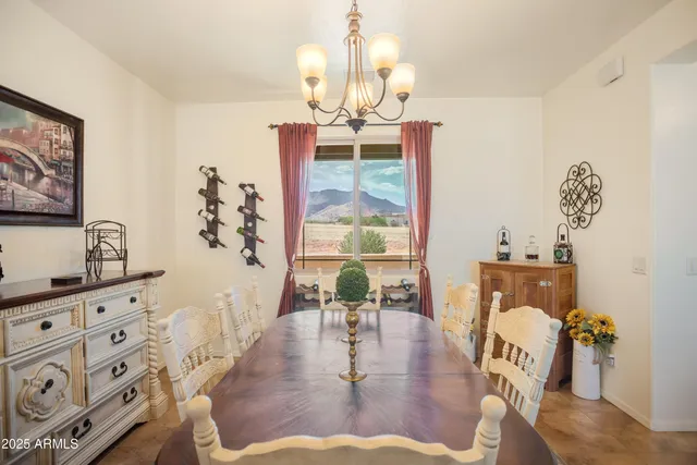 a dining room with wooden floor chandelier a wooden table and chairs