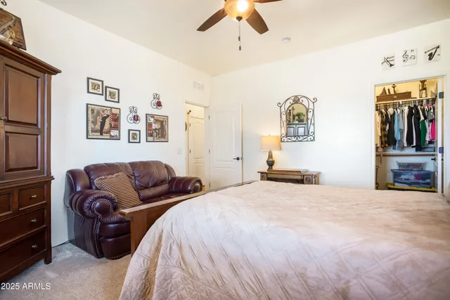 a bedroom with a bed couches and flat screen tv