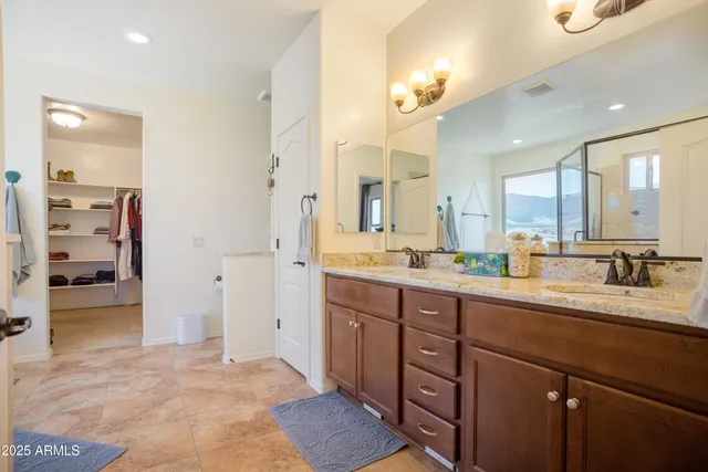 a spacious bathroom with a granite countertop sink mirror and a shower