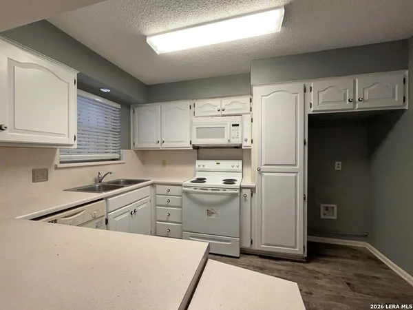 a kitchen with a sink a refrigerator and cabinets