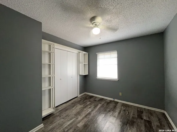 an empty room with wooden floor and chandelier fan