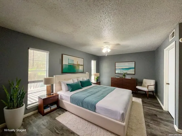 a bedroom with a large bed and a potted plant