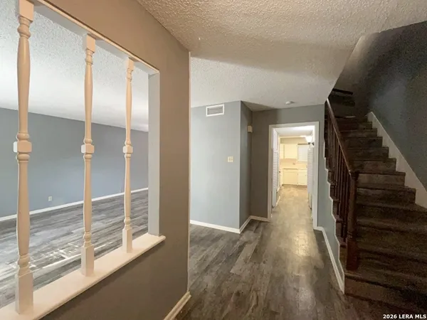 a view of hallway with stairs and wooden floor