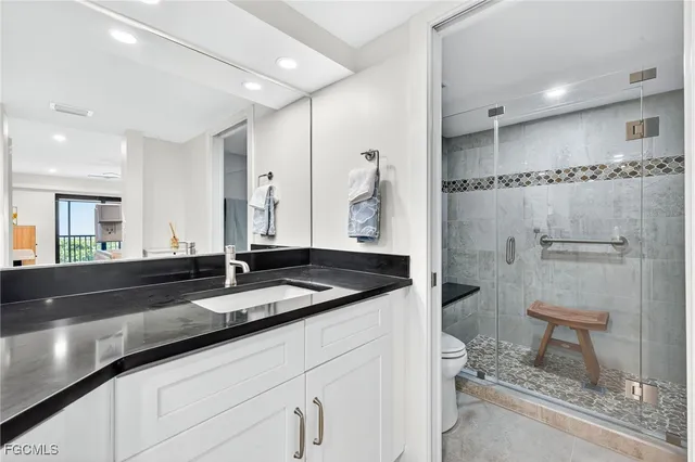 a bathroom with a granite countertop sink a mirror and a shower