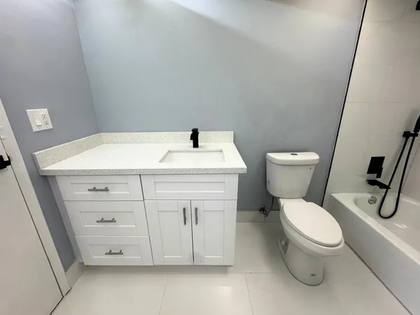 a white toilet sitting next to a bathroom sink