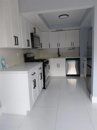 a kitchen with stainless steel appliances a sink stove and cabinets