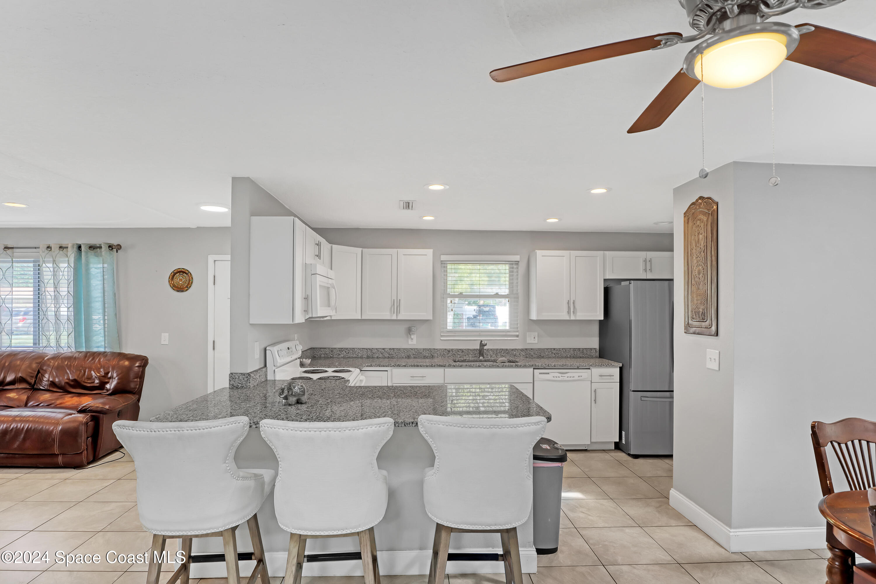 2581 Locksley Road Melbourne, FL 32935 - Photo 12 of 33 a kitchen with stainless steel appliances granite countertop a sink and a refrigerator