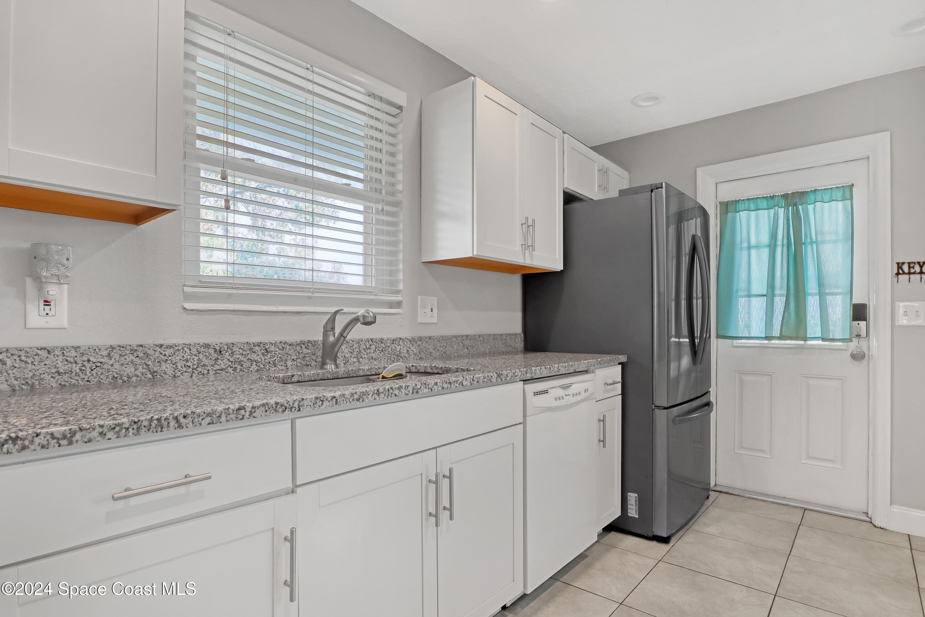 2581 Locksley Road Melbourne, FL 32935 - Photo 14 of 33 a kitchen with a refrigerator sink and cabinets