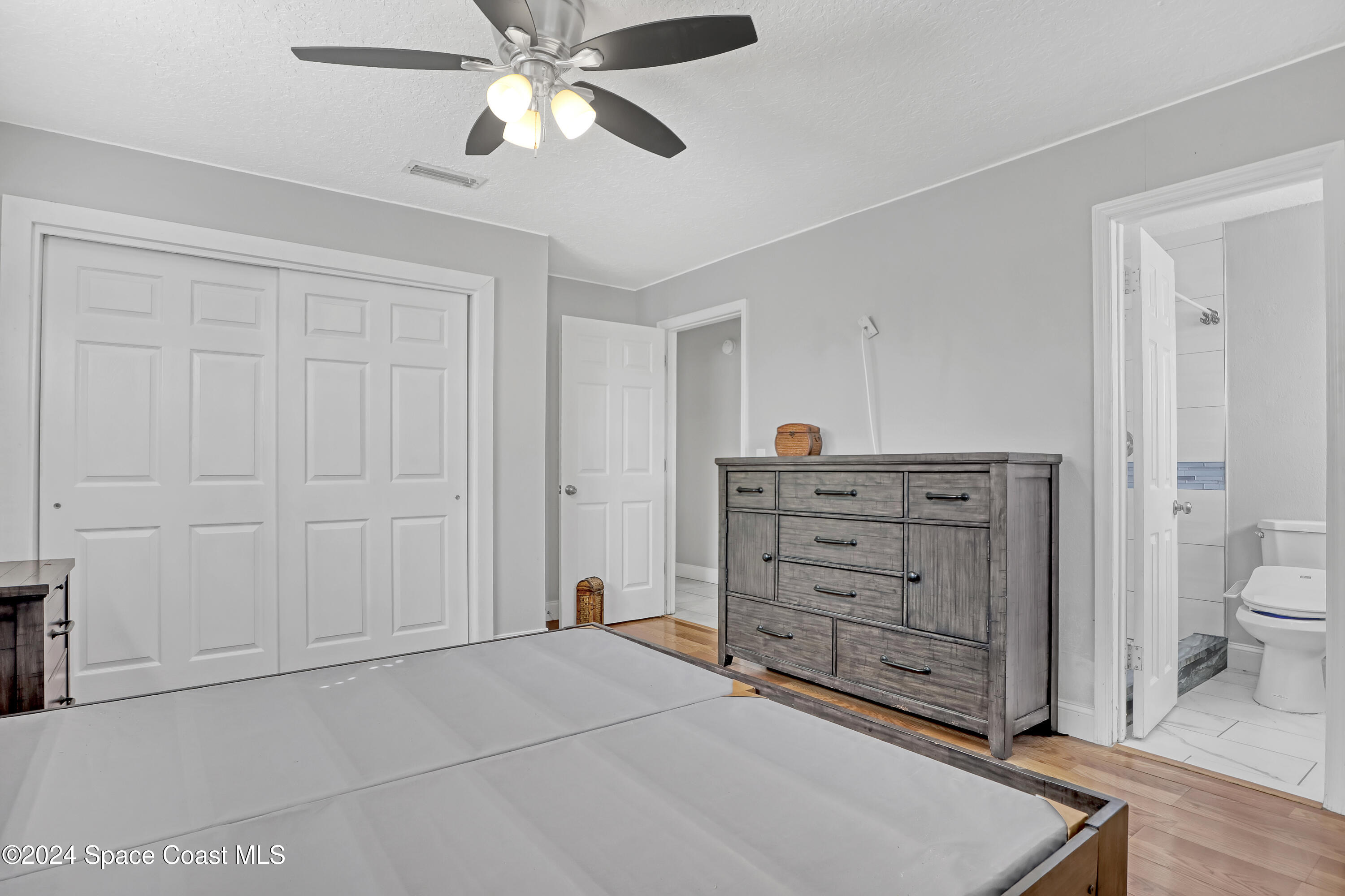 2581 Locksley Road Melbourne, FL 32935 - Photo 19 of 33 a room with a dresser and a chandelier