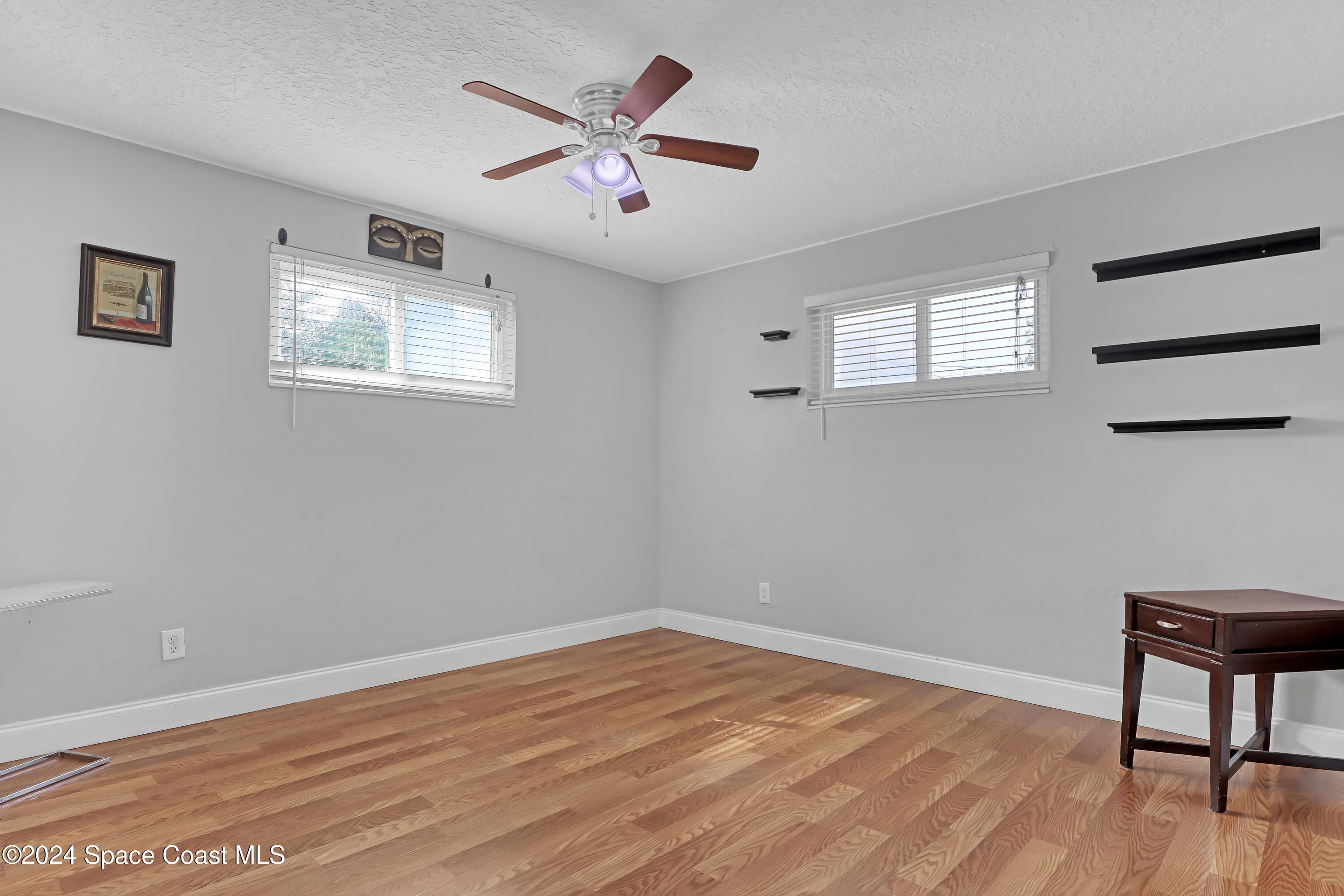 2581 Locksley Road Melbourne, FL 32935 - Photo 22 of 33 a view of a big room with wooden floor and a window