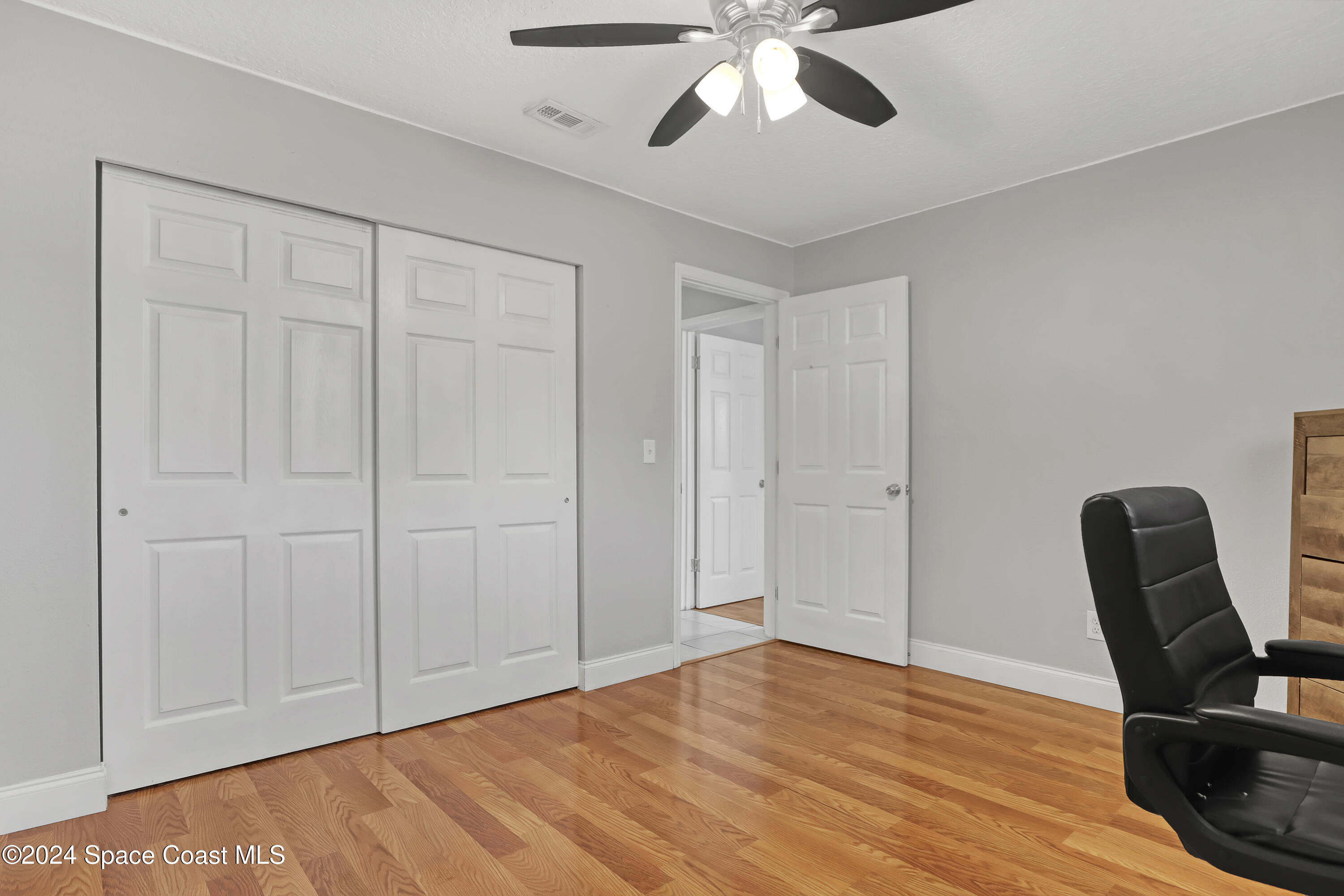 2581 Locksley Road Melbourne, FL 32935 - Photo 26 of 33 a view of an empty room with wooden floor and furniture