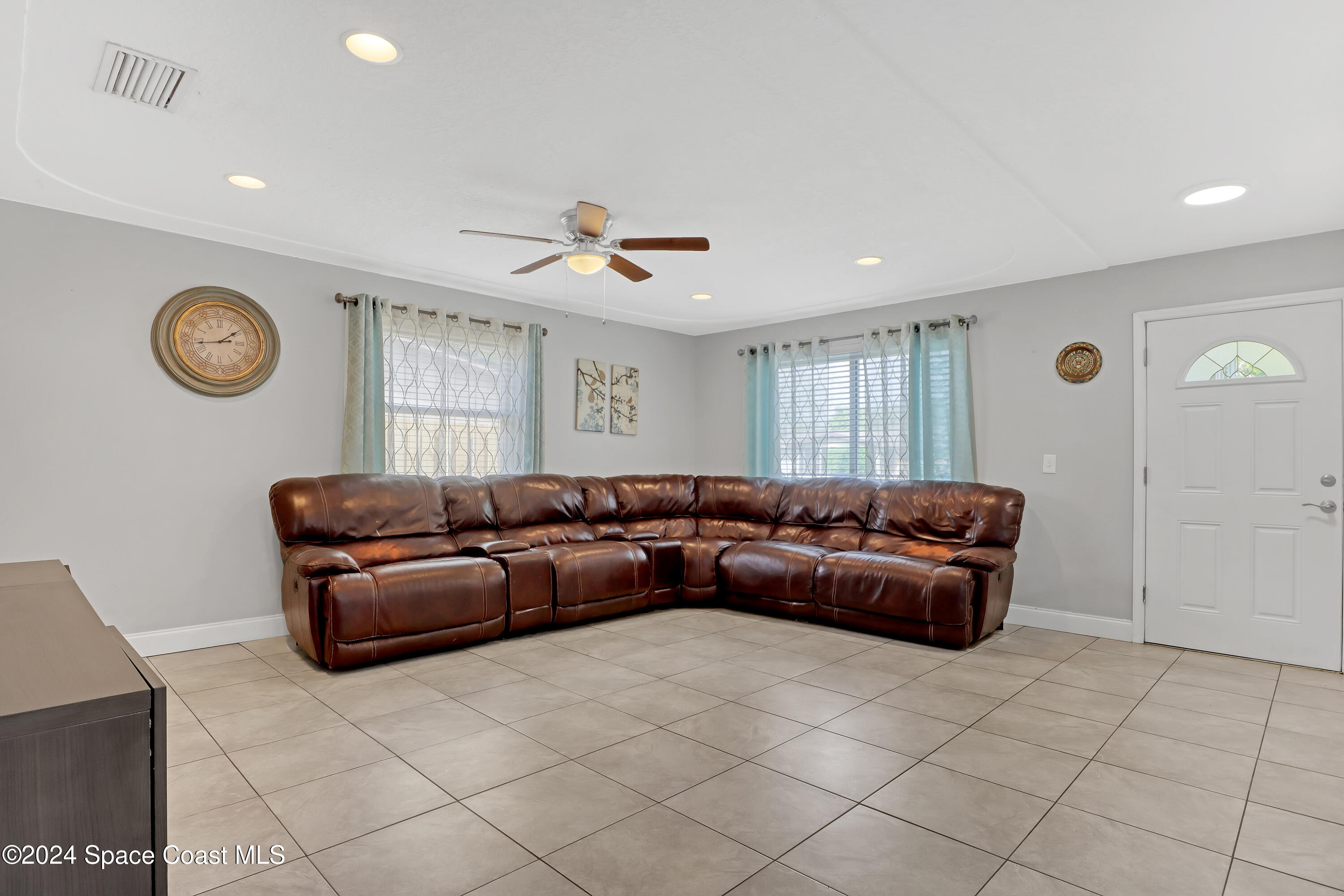 2581 Locksley Road Melbourne, FL 32935 - Photo 8 of 33 a living room with furniture and a clock