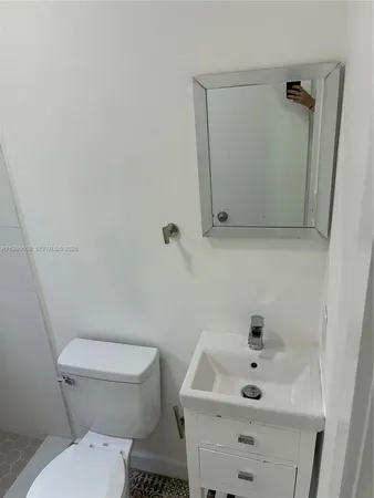 a white toilet sitting next to a bathroom sink
