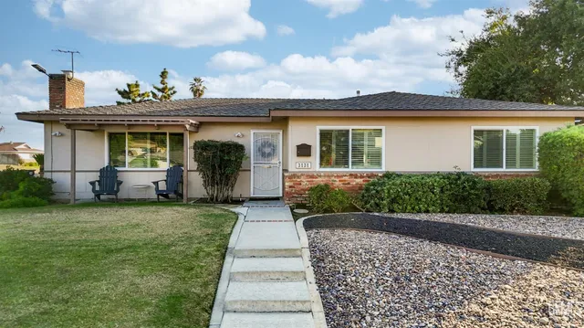 a front view of a house with a yard and potted plants