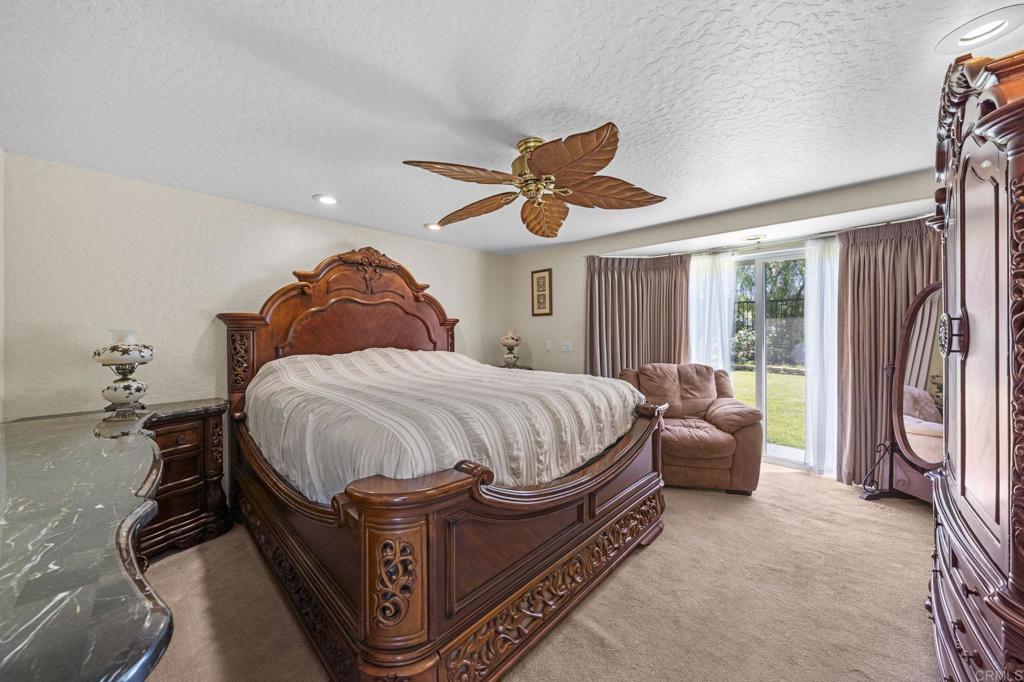 30265 Miller Road Valley Center, CA 92082 - Photo 20 of 56 a spacious bedroom with a bed and a chandelier