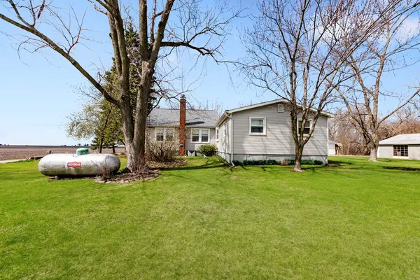 a backyard of a house with table and chairs