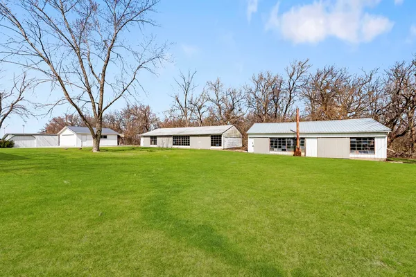 a front view of house with yard and trees in the background