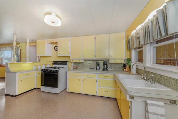 a kitchen with a sink stove and cabinets