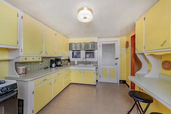a kitchen with a sink a stove and cabinets