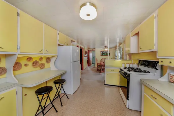 a kitchen with a stove a refrigerator and a microwave