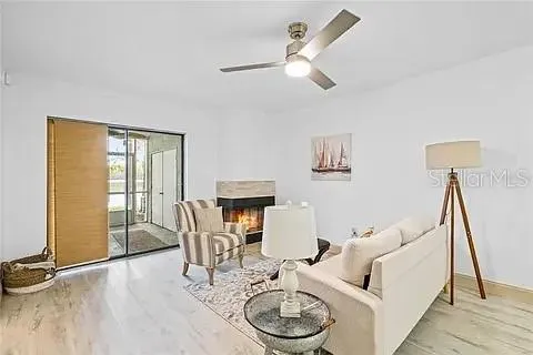 a living room with furniture a flat screen tv and a table