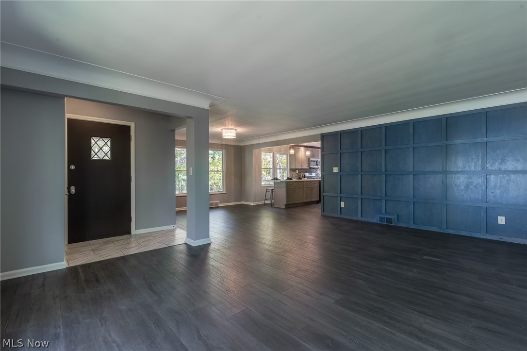 1393 Clearview Road Cleveland, OH 44124 - Photo 4 of 35 The foyer was opened to add to the expansive living area, that leads to the eat in kitchen. The wide plank wood laminate flooring continues throughout most of the first floor. Note the large windows, they have all been replaced with energy efficient Pella windows, no maintenance, easy to clean! The wall was remove to bring the kitchen into the main living space.