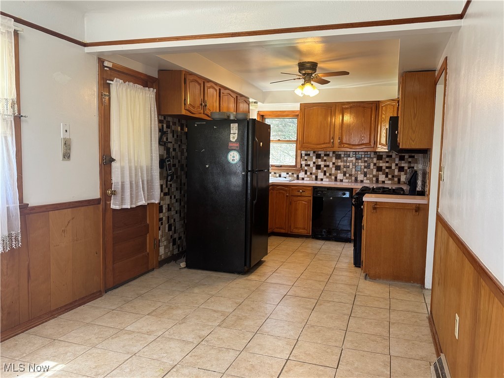 25911 Tryon Road Bedford, OH 44146 - Photo 11 of 49 Kitchen with a ceiling fan, a wainscoted wall, brown cabinetry, and black appliances