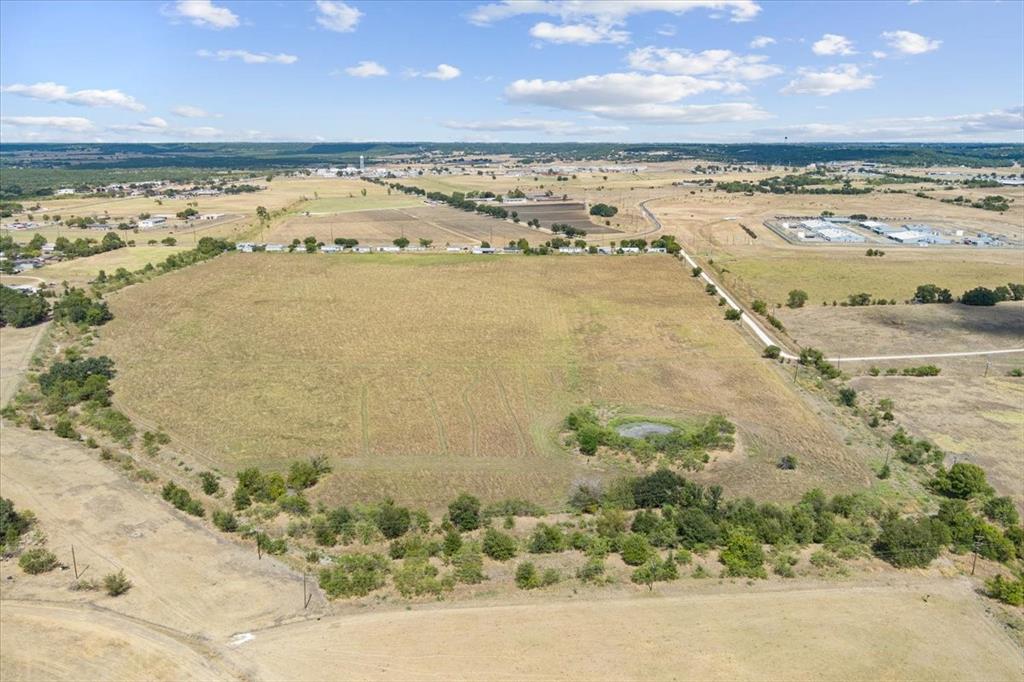 410 State School Road Gatesville, TX 76528 - Photo 18 of 39 Expansive open land with a visible pond, surrounded by varied terrain and distant development