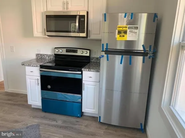 a kitchen with stainless steel appliances a stove microwave and a refrigerator